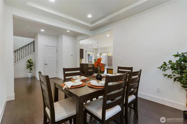 a view of a dining room and livingroom with furniture wooden floor and a potted plant