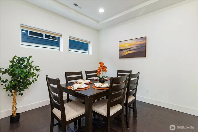a dining room with furniture and potted plants