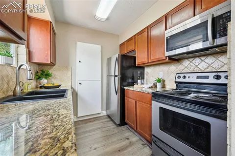 a kitchen with stainless steel appliances granite countertop a stove a microwave and a refrigerator
