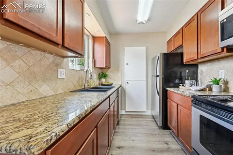 a kitchen with stainless steel appliances granite countertop a stove a sink and a refrigerator