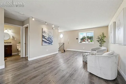 a living room with furniture and a wooden floor