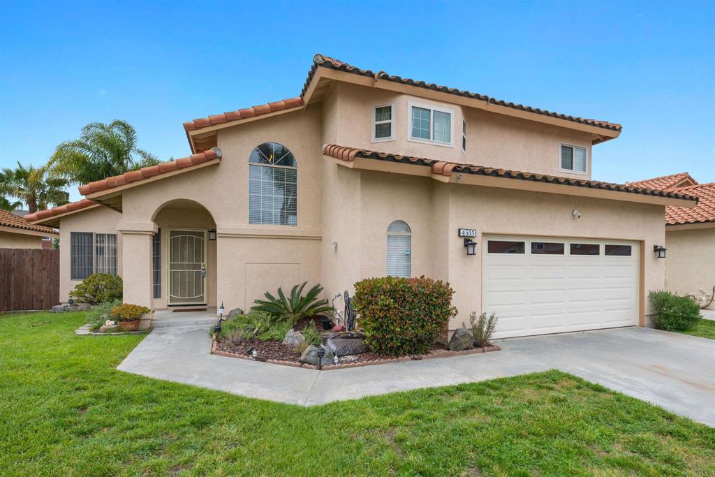 a front view of a house with a garden and plants