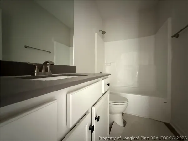 a bathroom with a sink a toilet a shower and a mirror