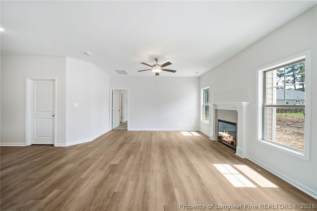 4038 Lofton Street Wade, NC 28395 - Photo 14 of 29 a view of empty room with wooden floor and fireplace