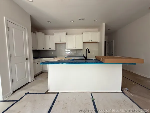 a kitchen with kitchen island cabinets and white appliances
