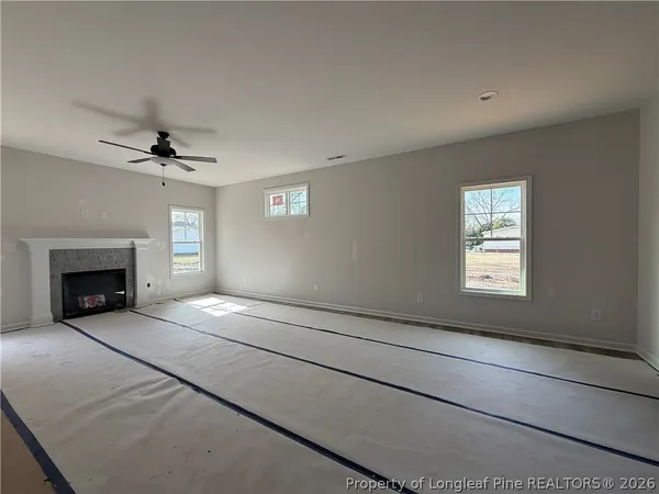 a view of an empty room with a fireplace and a window
