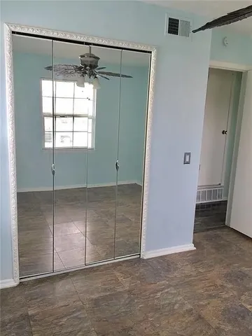 an empty room with windows and closet