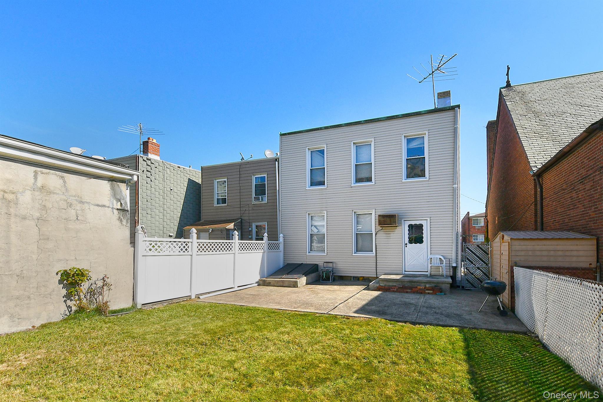 30-94 47th Street Queens, NY 11103 - Photo 4 of 20 Rear view of property featuring a patio area and a fenced backyard