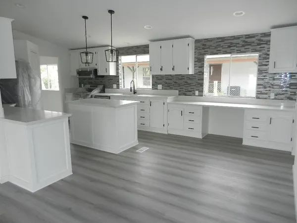 a kitchen with kitchen island granite countertop a sink a center island and cabinets
