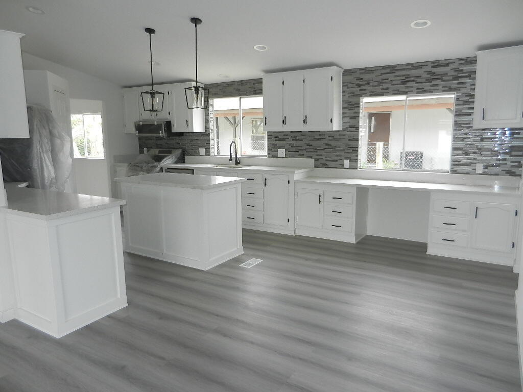 98920 Surfside Avenue Mecca, CA 92254 - Photo 1 of 22 a kitchen with kitchen island granite countertop a sink a center island and cabinets