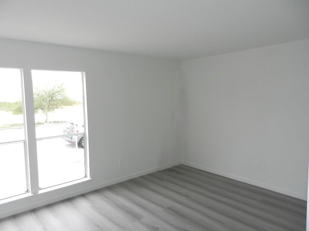 98920 Surfside Avenue Mecca, CA 92254 - Photo 13 of 22 an empty room with wooden floor and windows