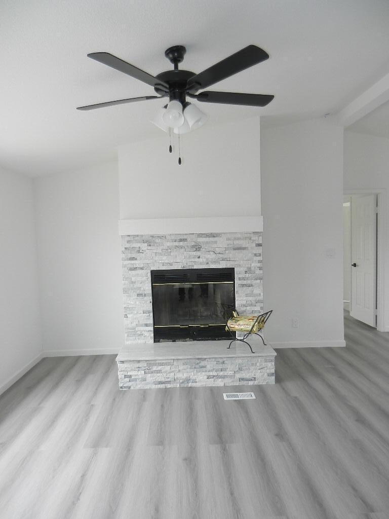 98920 Surfside Avenue Mecca, CA 92254 - Photo 4 of 22 an empty room with wooden floor a fireplace and windows