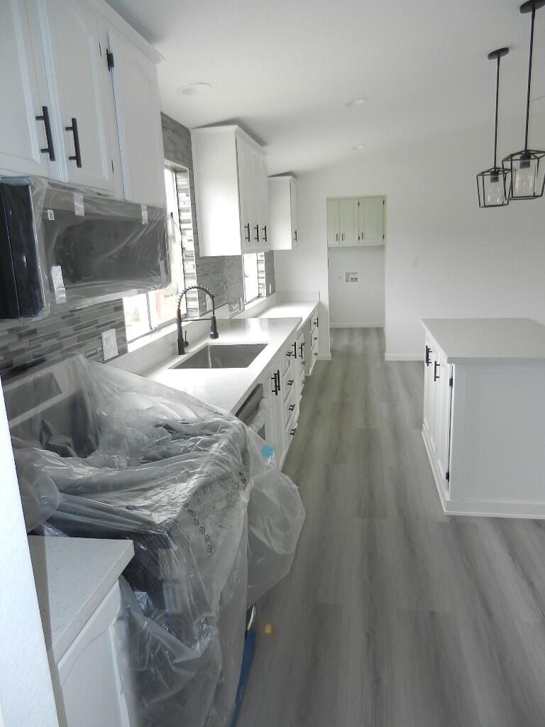 98920 Surfside Avenue Mecca, CA 92254 - Photo 9 of 22 a kitchen with stainless steel appliances kitchen island granite countertop a sink dishwasher stove and cabinets