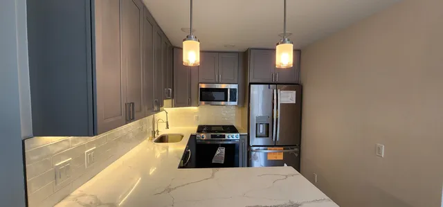 a kitchen with a refrigerator a stove and a wooden floor