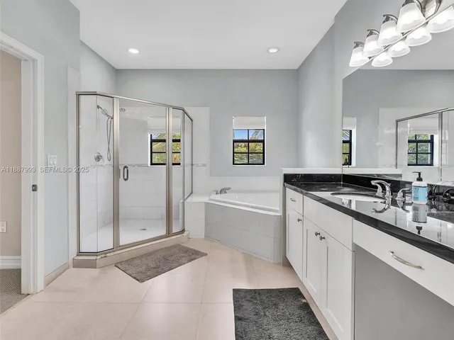 a spacious bathroom with a double vanity sink mirror and shower