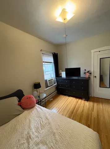 a bedroom with a bed and wooden floor