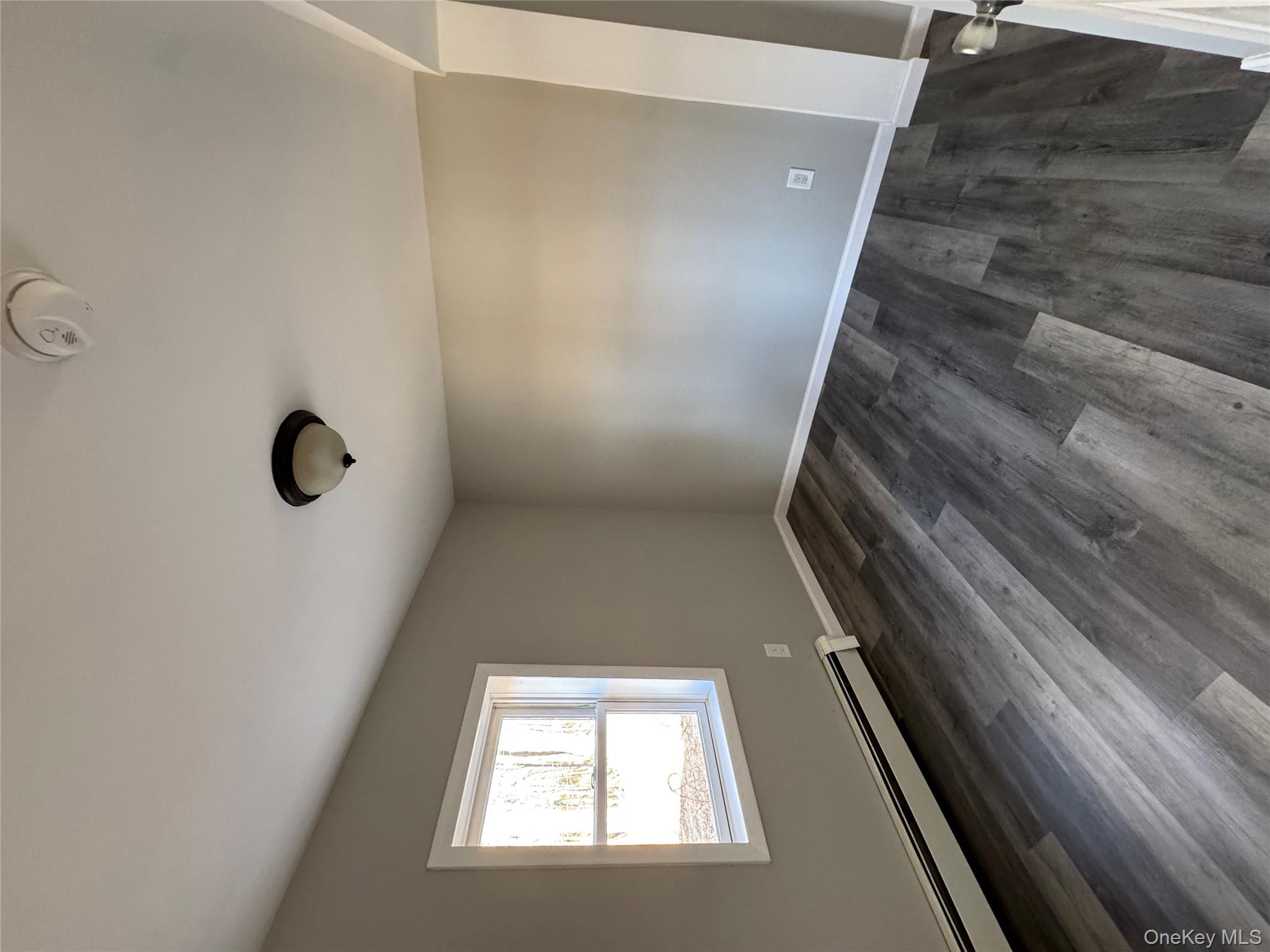 654 Milltown Road Danbury, CT 06811 - Photo 15 of 33 an empty room with wooden floor and windows