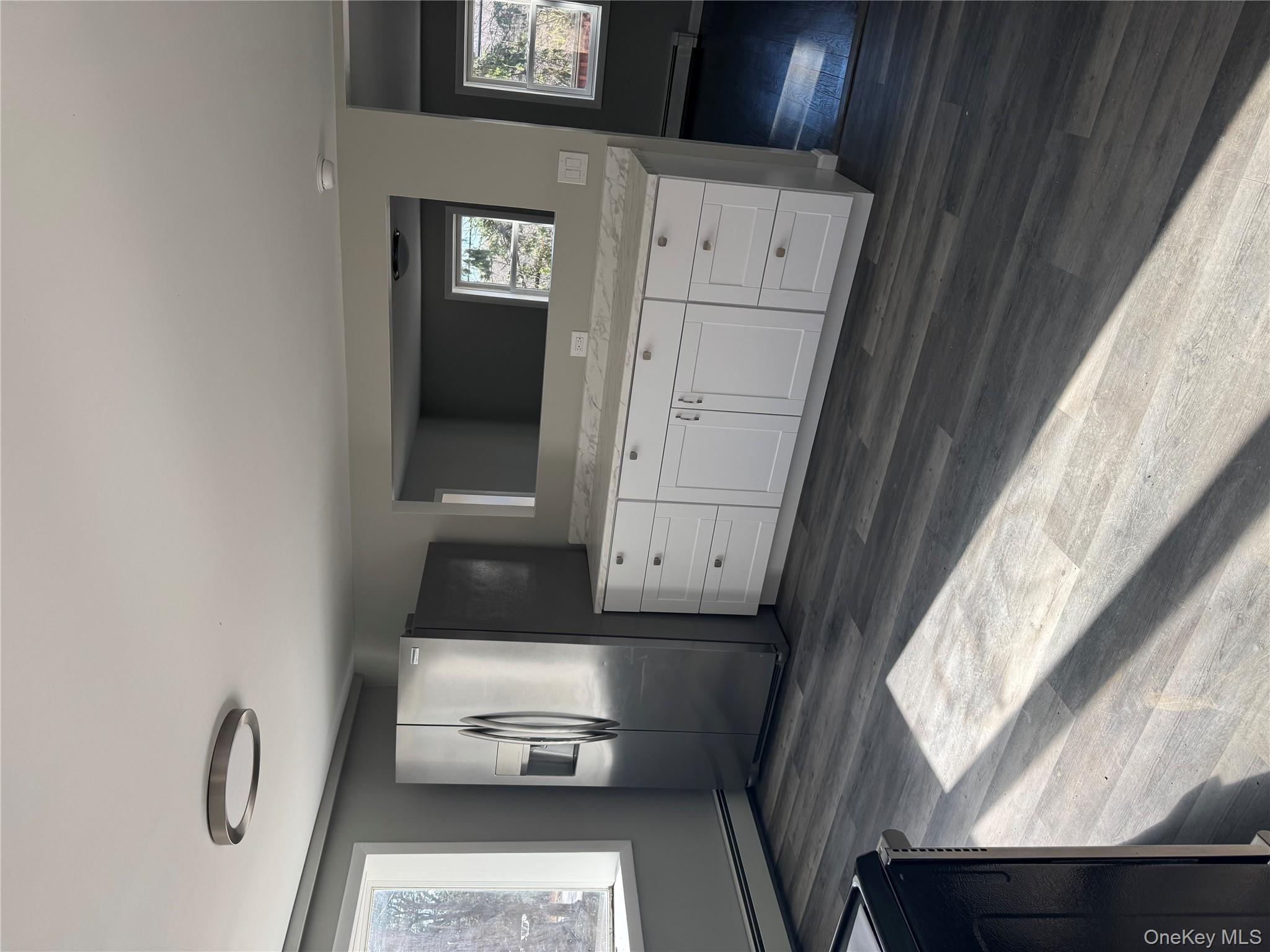 654 Milltown Road Danbury, CT 06811 - Photo 8 of 33 a view of an empty room and window with wooden floor