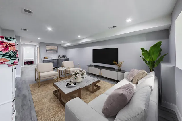 a living room with furniture a flat screen tv and a potted plant