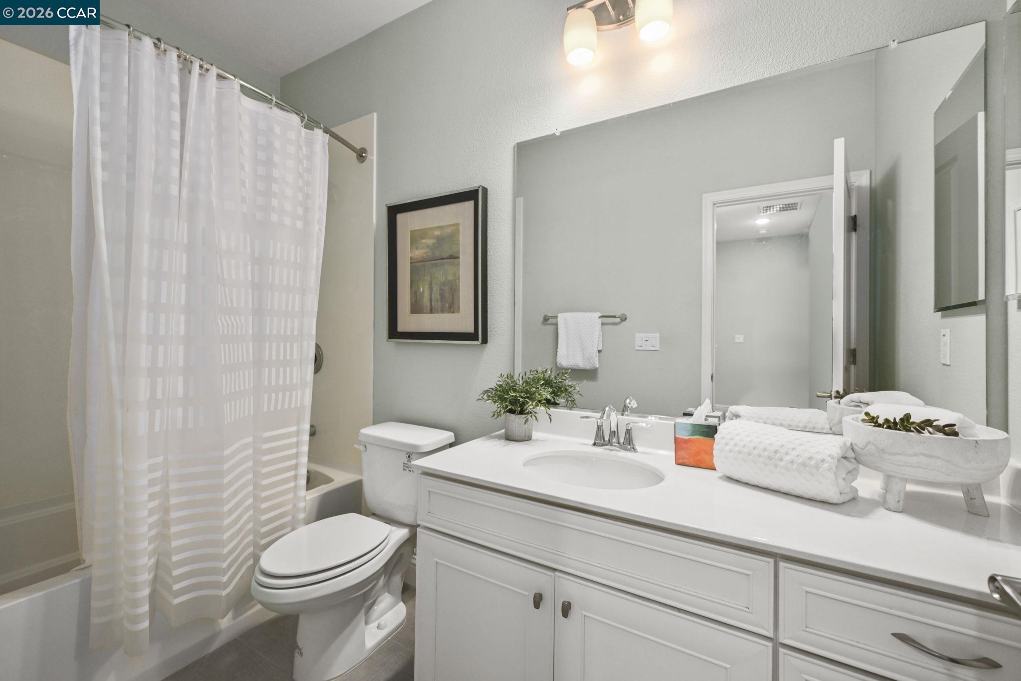 3923 Meridian Street Dublin, CA 94568 - Photo 22 of 39 a bathroom with a sink a toilet and shower curtain