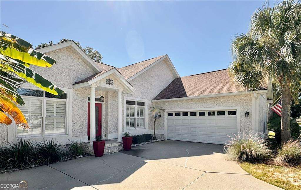 a view of a white house with potted plants in front of it