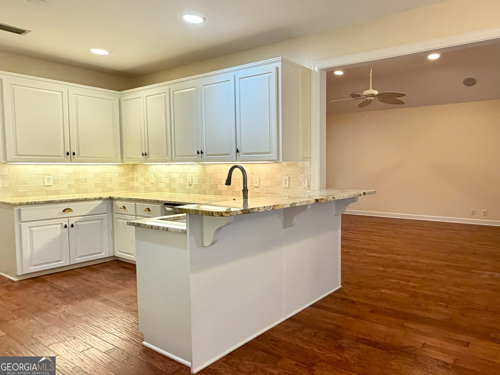 317 Commons Road St. Simons, GA 31522 - Photo 15 of 44 a kitchen with a sink cabinets and wooden floor