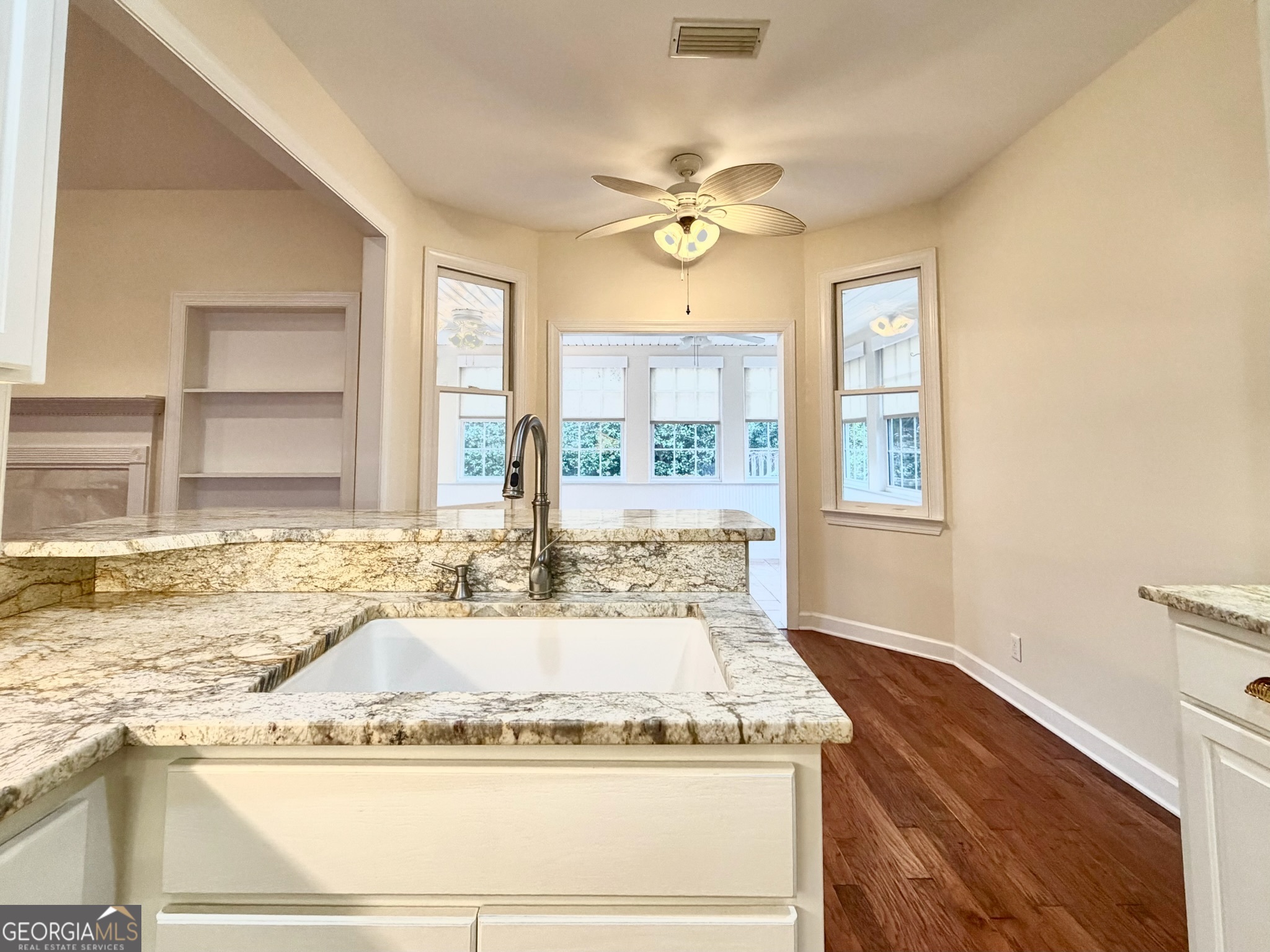 317 Commons Road St. Simons, GA 31522 - Photo 16 of 44 a bathroom with a granite countertop sink a large mirror and a bathtub next to a window