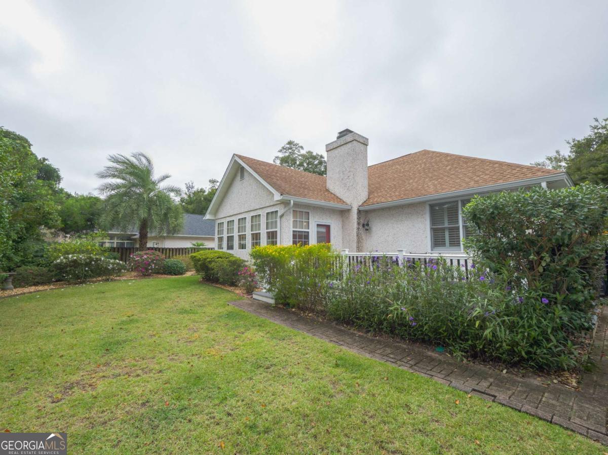 317 Commons Road St. Simons, GA 31522 - Photo 2 of 44 a front view of a house with garden