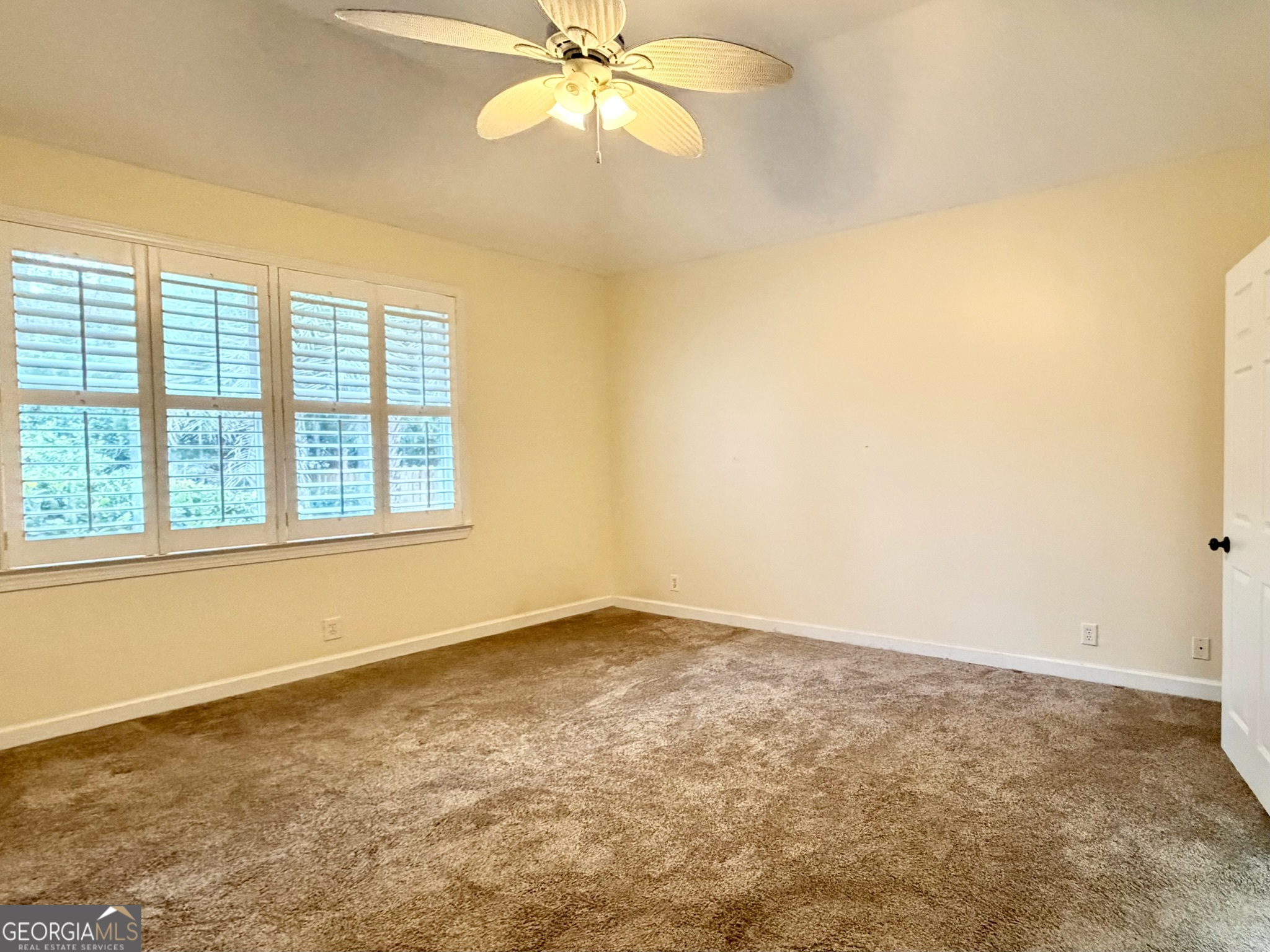 317 Commons Road St. Simons, GA 31522 - Photo 23 of 44 an empty room with a window and a fan