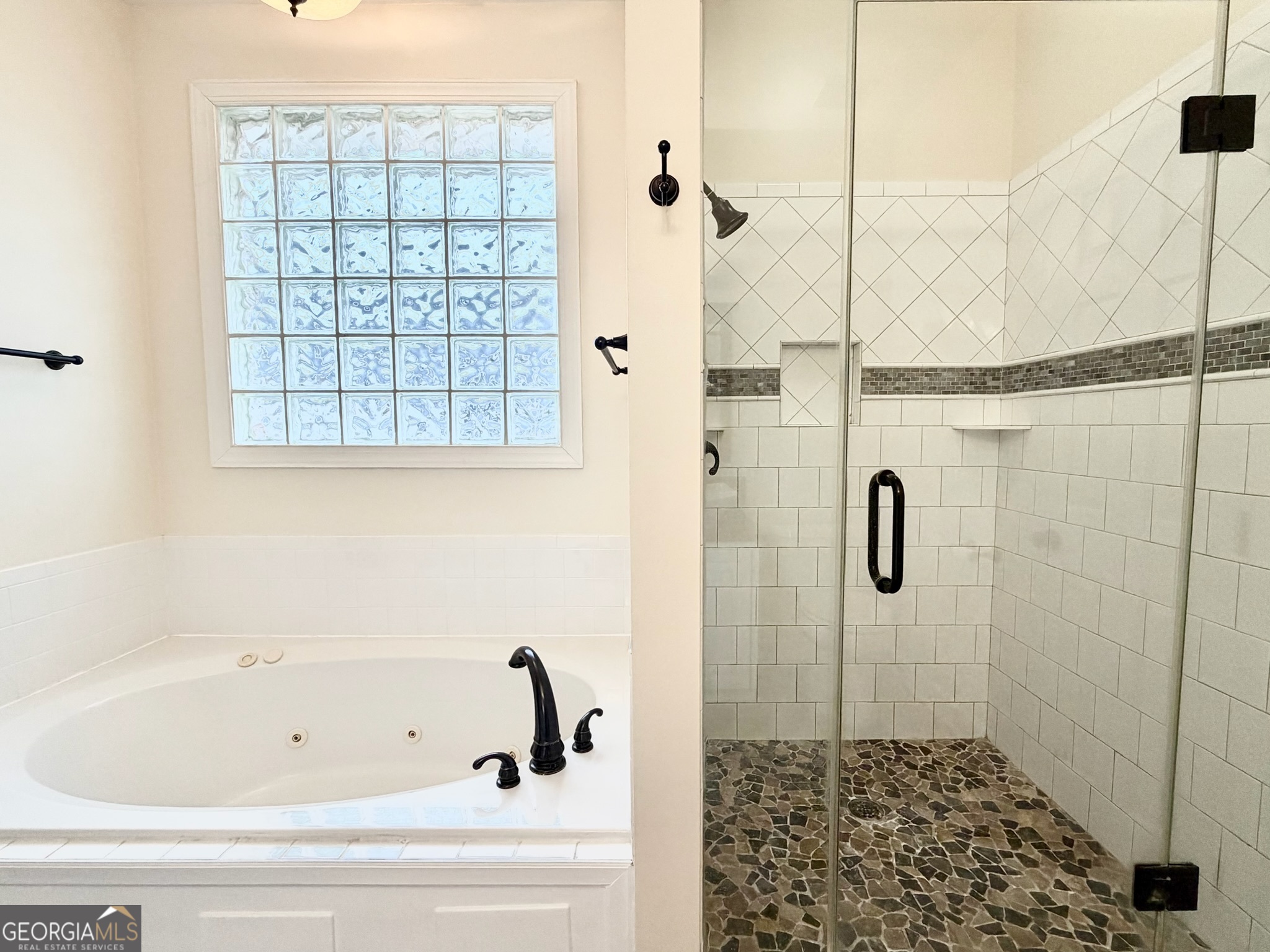 317 Commons Road St. Simons, GA 31522 - Photo 24 of 44 a bathroom with a bathtub and shower