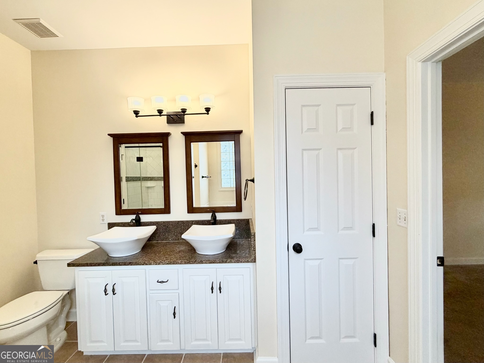 317 Commons Road St. Simons, GA 31522 - Photo 25 of 44 a bathroom with a sink and a mirror with toilet