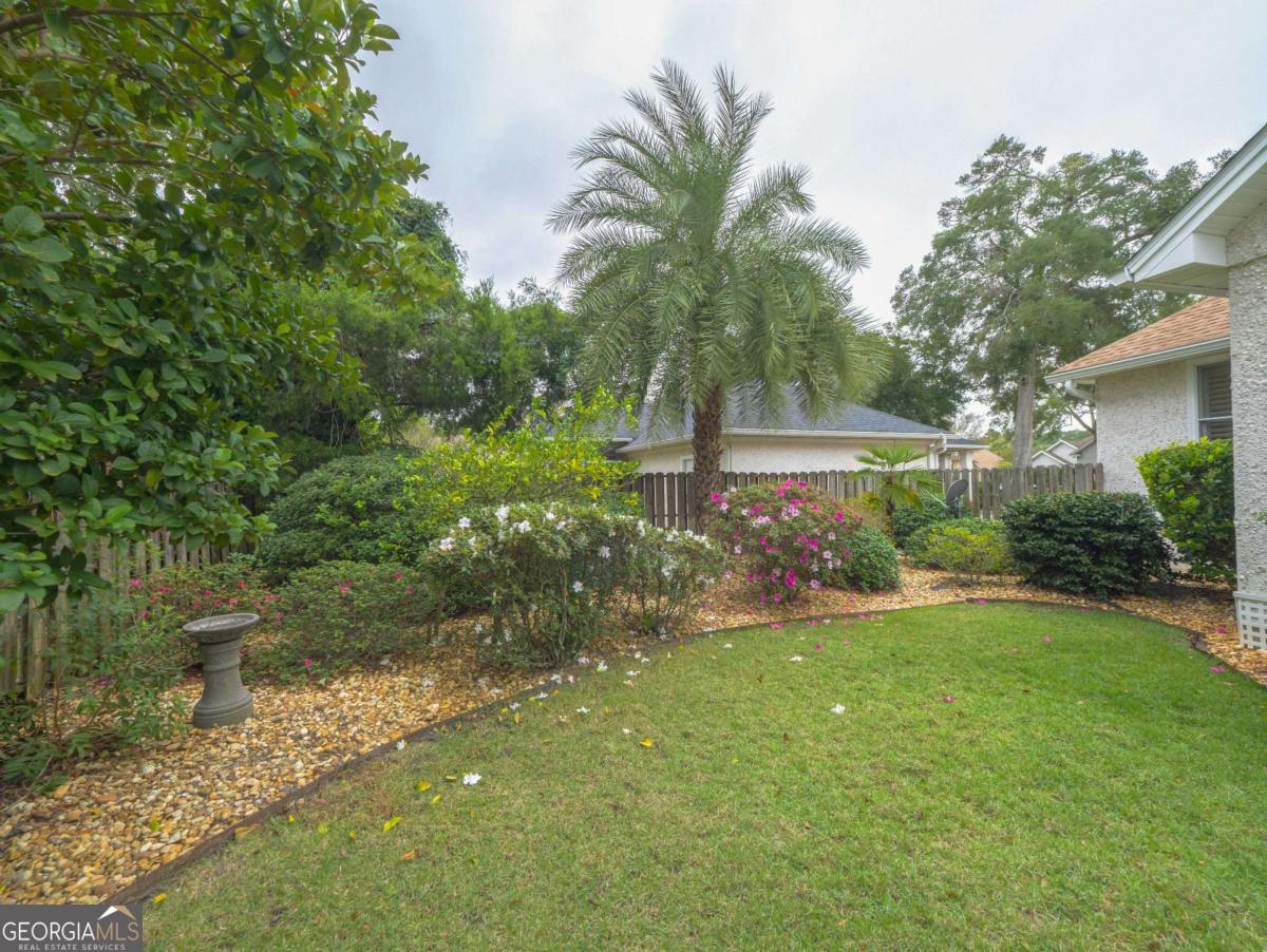 317 Commons Road St. Simons, GA 31522 - Photo 3 of 44 a view of a garden with palm trees