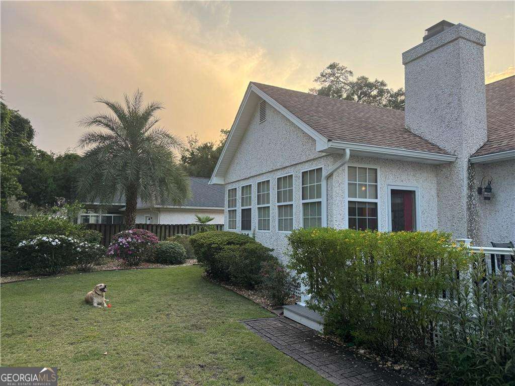 317 Commons Road St. Simons, GA 31522 - Photo 33 of 44 a front view of a house with garden