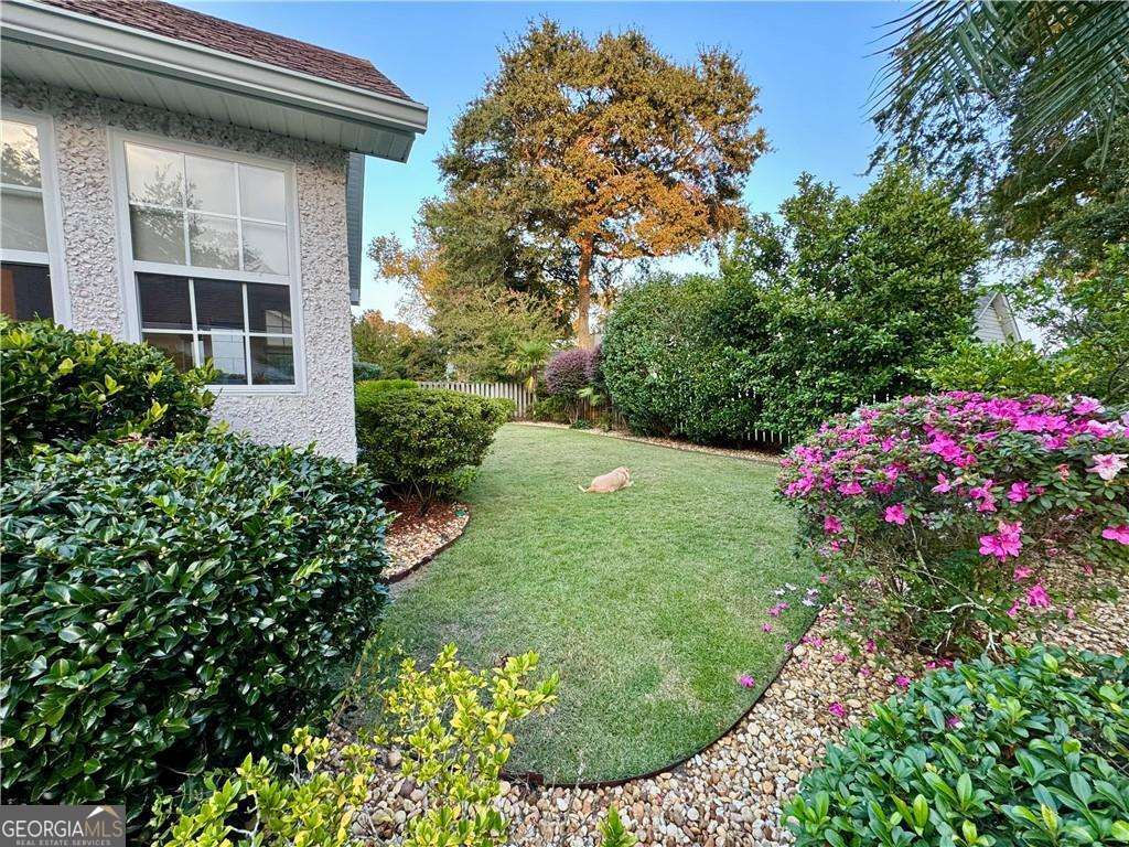 317 Commons Road St. Simons, GA 31522 - Photo 35 of 44 a view of a house with a flower garden