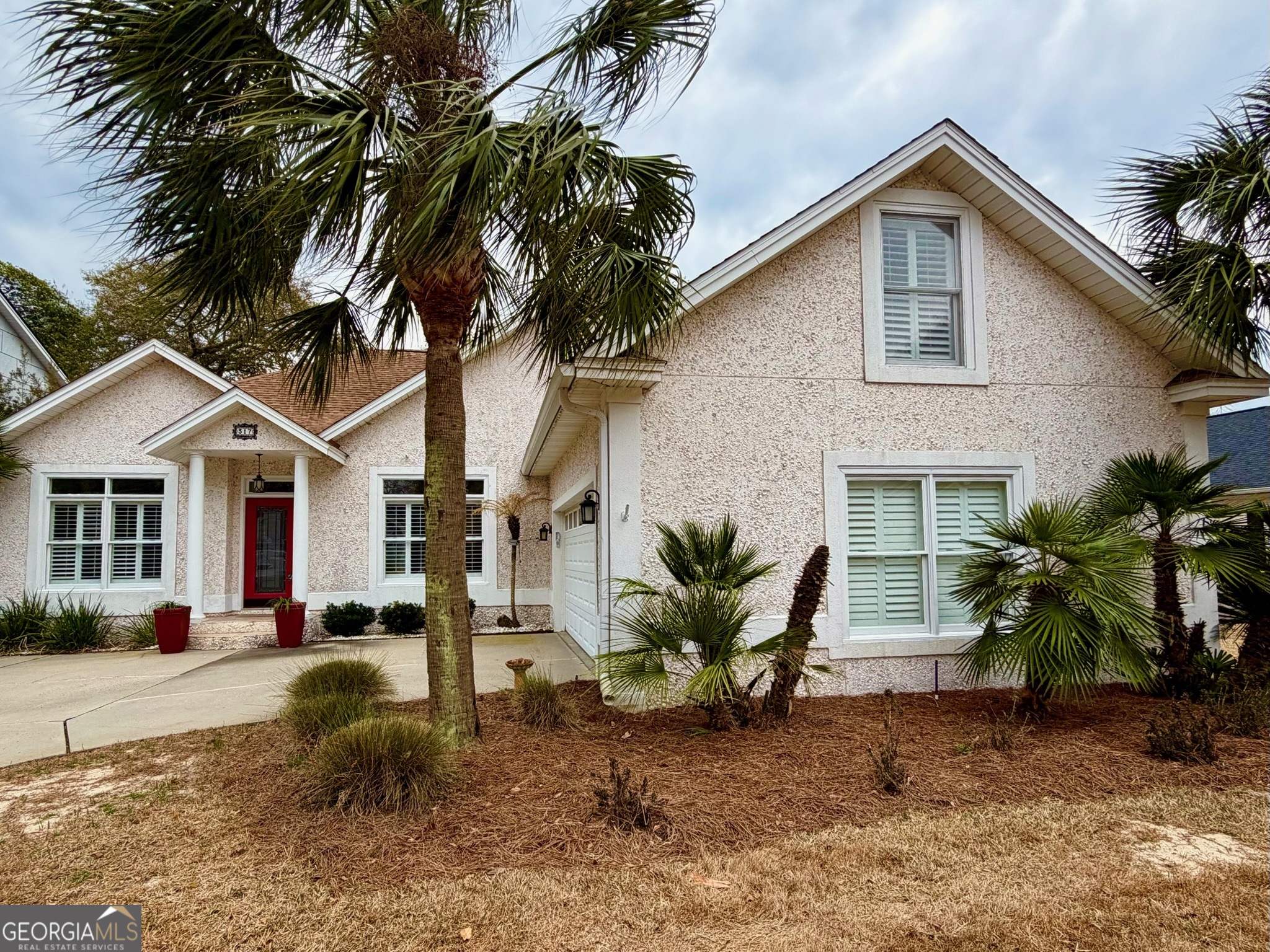 317 Commons Road St. Simons, GA 31522 - Photo 41 of 44 a view of a yard in front of a house with cars parked