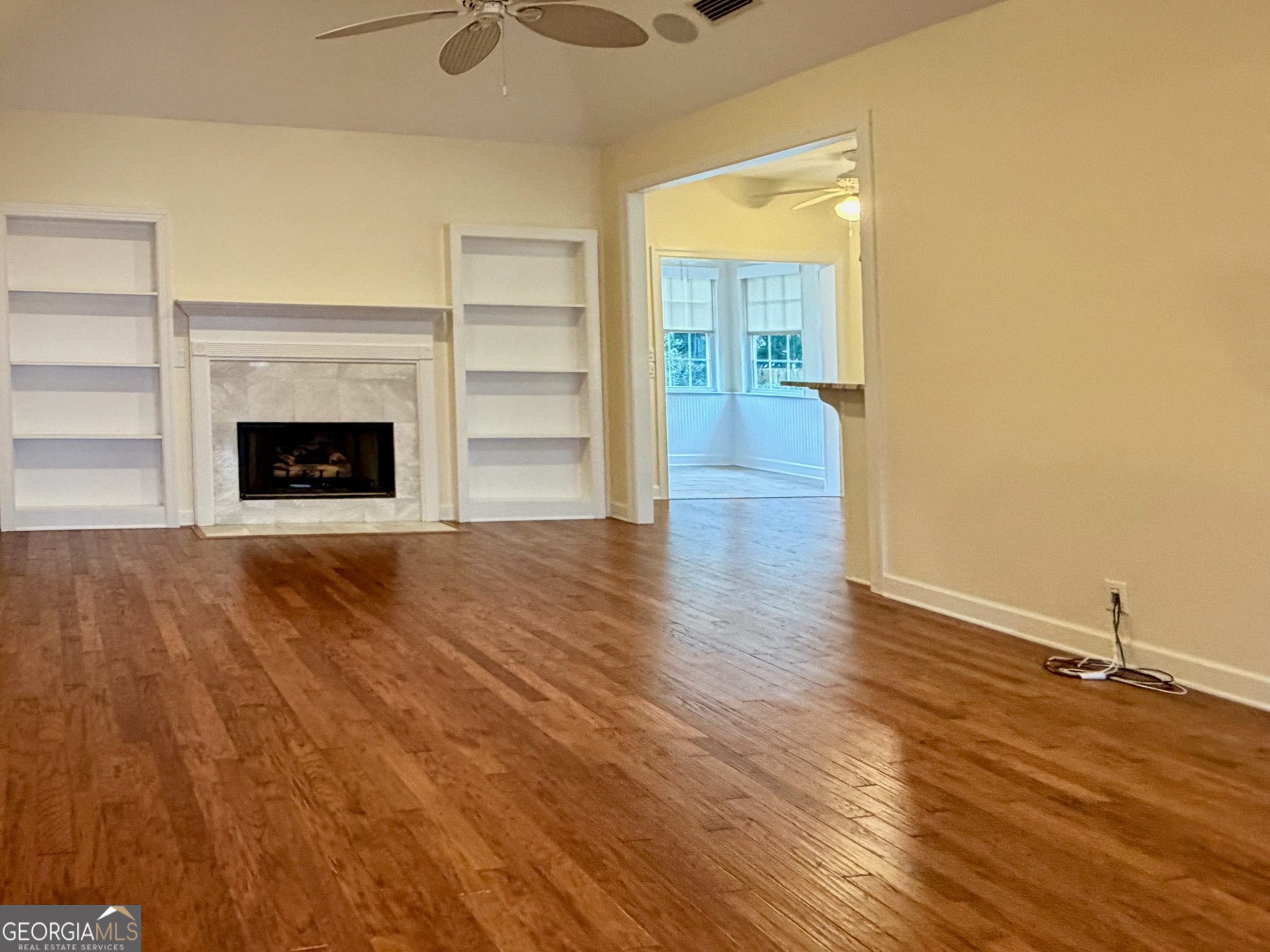 317 Commons Road St. Simons, GA 31522 - Photo 7 of 44 a view of a room with wooden floor a fireplace and window