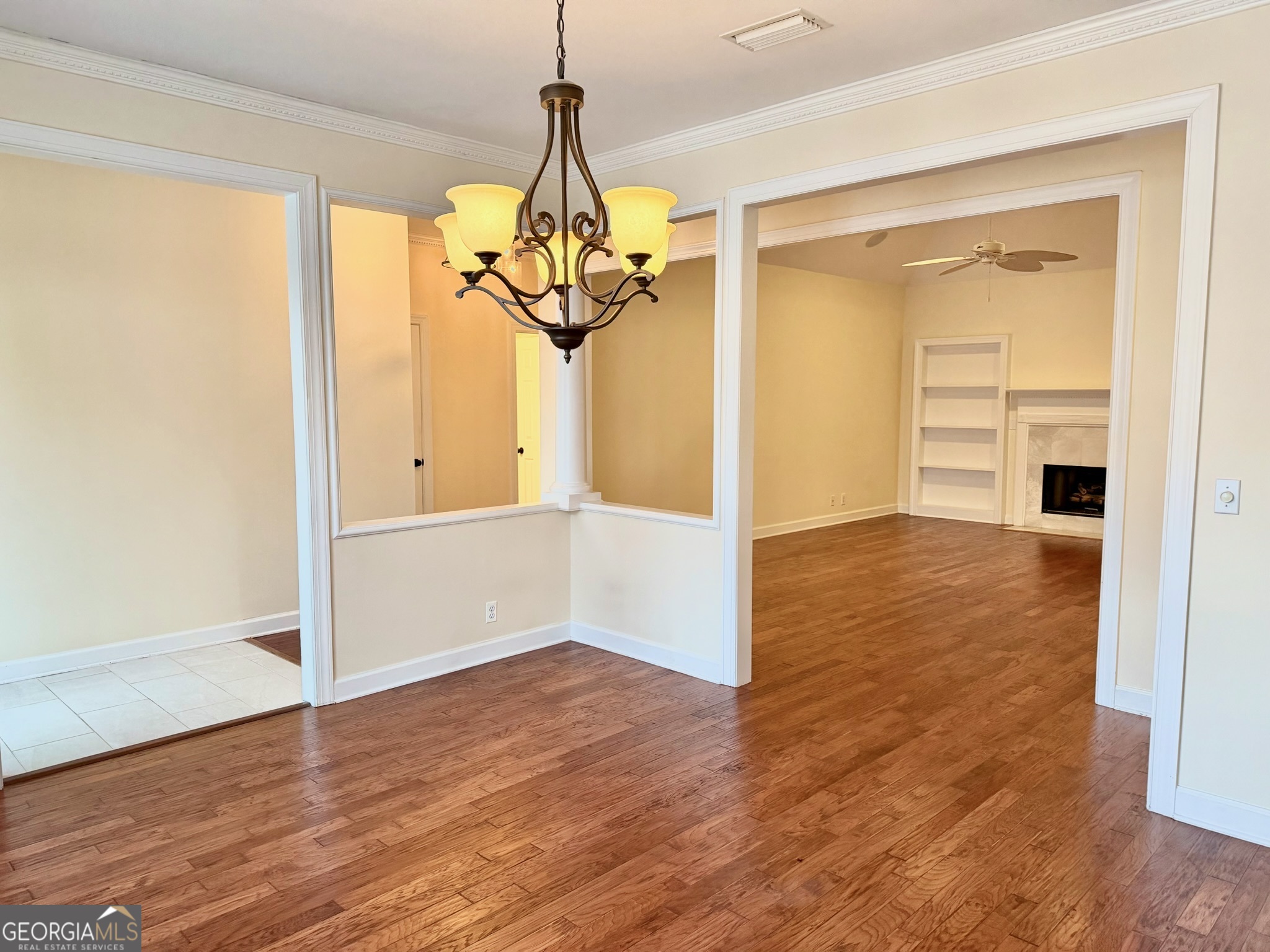 317 Commons Road St. Simons, GA 31522 - Photo 10 of 44 a view of a hallway with wooden floor and a chandelier