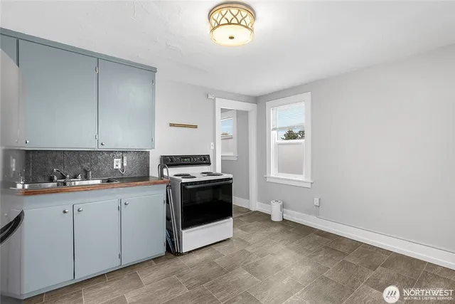 a kitchen with a stove and white cabinets