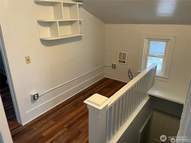 a view of a kitchen with wooden floor and a window