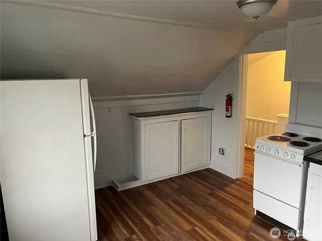 a kitchen with white cabinets and white appliances