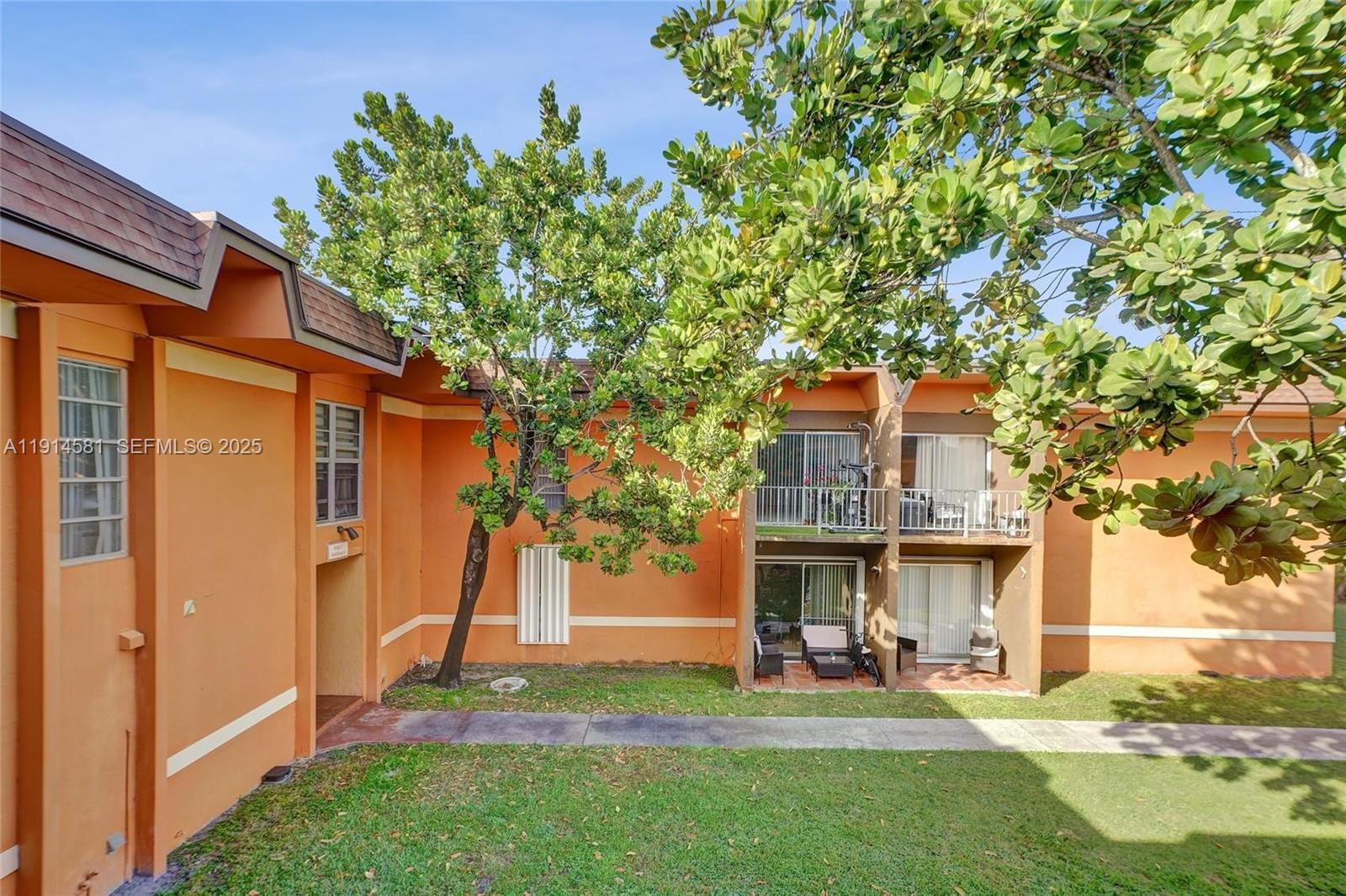 9459 Southwest 76th Street, Unit R7 Miami, FL 33173 - Photo 12 of 21 a view of a brick house with a big yard and large tree