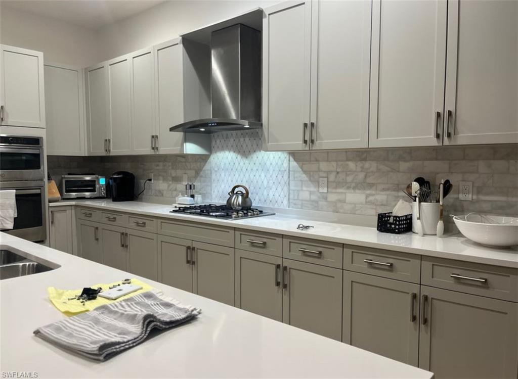 12181 Eucalyptus Way Naples, FL 34120 - Photo 11 of 13 a kitchen with stainless steel appliances granite countertop a sink a stove and white cabinets