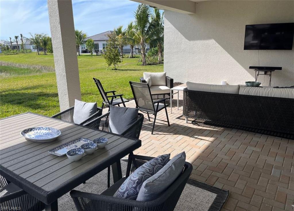 12181 Eucalyptus Way Naples, FL 34120 - Photo 13 of 13 a view of a patio with lawn chairs floor to ceiling window and a yard