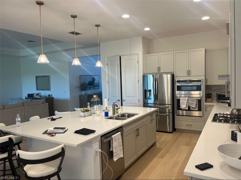 12181 Eucalyptus Way Naples, FL 34120 - Photo 2 of 13 a kitchen with stainless steel appliances kitchen island granite countertop a sink a stove and a refrigerator