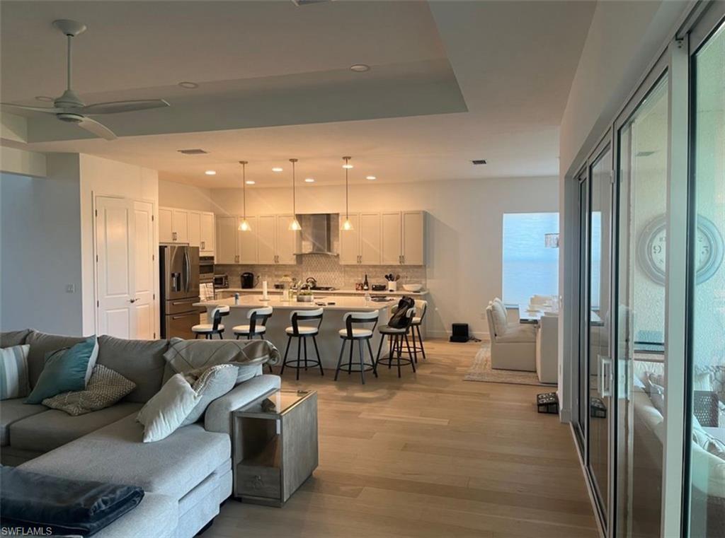 12181 Eucalyptus Way Naples, FL 34120 - Photo 3 of 13 a living room with lots of furniture and a dining table