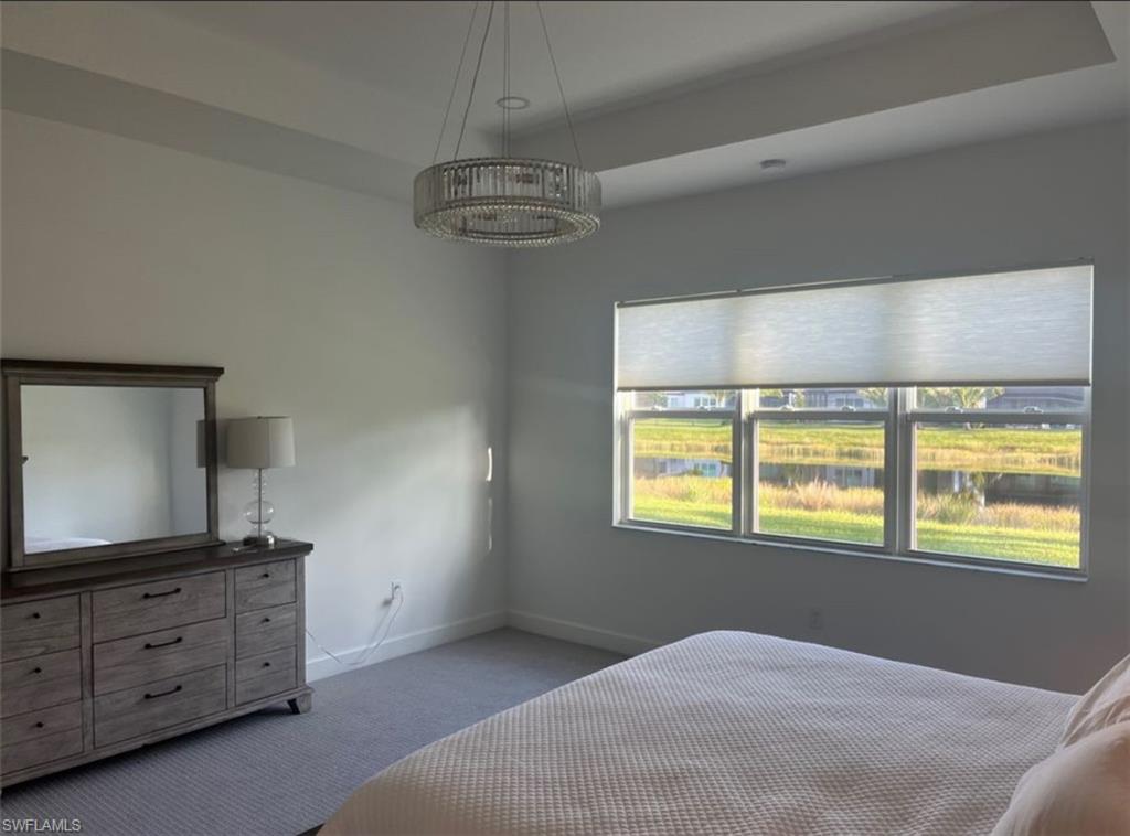 12181 Eucalyptus Way Naples, FL 34120 - Photo 4 of 13 a bedroom with a bed and a flat tv screen on dresser