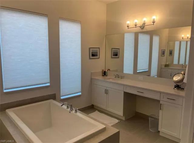a bathroom with a tub sink and mirror