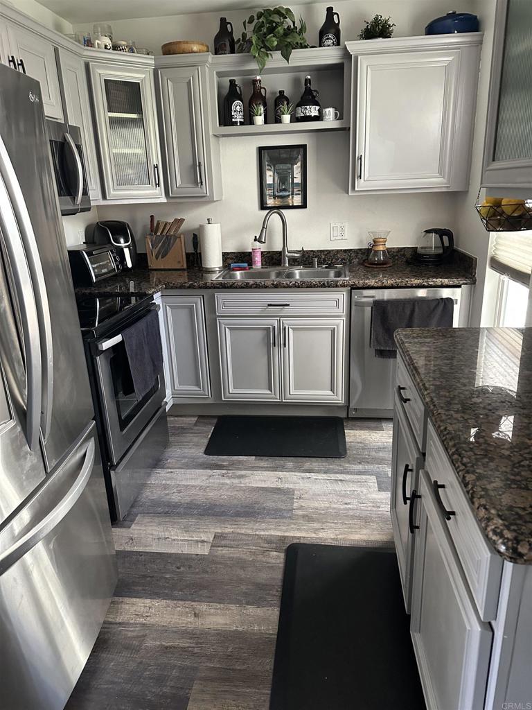 1401 Reed Avenue, Unit 3 San Diego, CA 92109 - Photo 2 of 16 a kitchen with stainless steel appliances granite countertop a stove a sink and a microwave