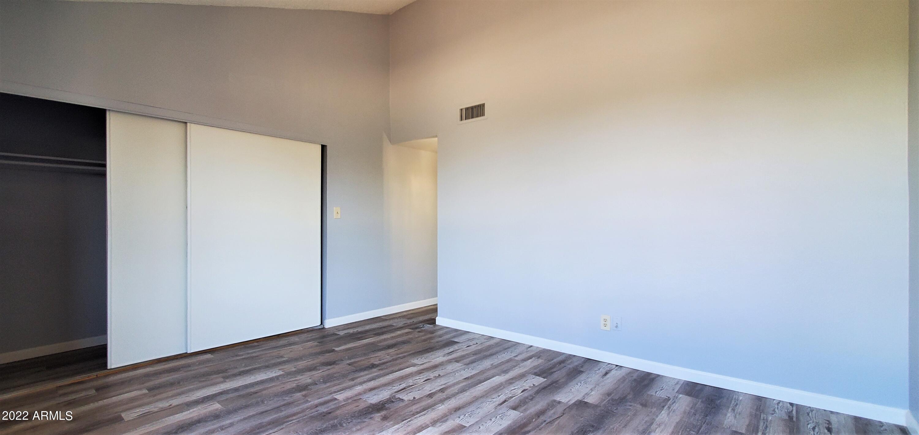 3411 North 12th Place, Unit 8 Phoenix, AZ 85014 - Photo 19 of 41 a view of an empty room with wooden floor and closet