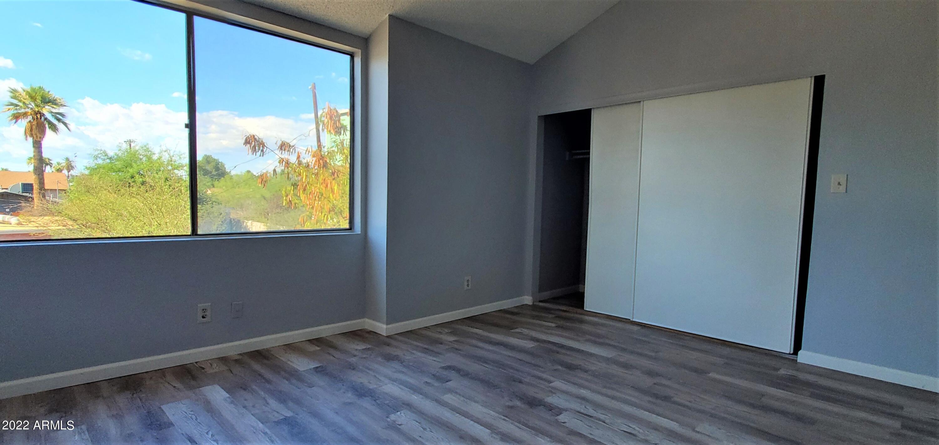 3411 North 12th Place, Unit 8 Phoenix, AZ 85014 - Photo 20 of 41 an empty room with wooden floor and windows